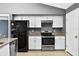 Kitchen featuring stainless steel appliances, granite countertops, white cabinets, and tile flooring for easy maintenance at 2476 Magellan Ave, Spring Hill, FL 34608