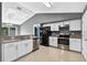 Bright kitchen with white cabinetry, granite countertops, stainless steel appliances, and an open layout to the dining area at 2476 Magellan Ave, Spring Hill, FL 34608