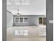 Bright living room with shiny tile flooring, fan, and slider leading to the backyard at 2476 Magellan Ave, Spring Hill, FL 34608