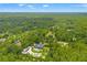 Aerial view displays a large estate surrounded by dense trees, a beautiful pool, and a utility building at 26221 Pheasant Run, Wesley Chapel, FL 33544