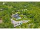 This aerial showcases a beautiful home with a backyard pool oasis, various buildings, and lush landscaping at 26221 Pheasant Run, Wesley Chapel, FL 33544