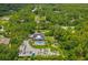 Expansive aerial view shows a property with a large pool, storage buildings, and landscaping at 26221 Pheasant Run, Wesley Chapel, FL 33544