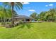 Manicured backyard showcasing lush greenery, mature trees, and comfortable lounge seating at 26221 Pheasant Run, Wesley Chapel, FL 33544
