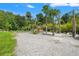 Spacious backyard featuring a charming pergola, green grass, tropical plants, and ample space for outdoor activities at 26221 Pheasant Run, Wesley Chapel, FL 33544
