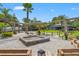 Expansive backyard featuring a fire pit, tropical landscaping, a covered pergola, and ample space for outdoor gatherings at 26221 Pheasant Run, Wesley Chapel, FL 33544