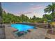 Beautiful backyard features a sparkling pool, spa, lush landscaping, and stylish outdoor seating at 26221 Pheasant Run, Wesley Chapel, FL 33544