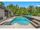 Beautiful backyard features a sparkling pool, spa, lush landscaping, and stylish outdoor seating at 26221 Pheasant Run, Wesley Chapel, FL 33544
