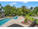 Gorgeous backyard oasis featuring a pool with waterfall feature, lush landscaping, and pavers at 26221 Pheasant Run, Wesley Chapel, FL 33544