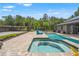 Inviting backyard boasts a spa, pool, brick pavers, and a large garage for extra storage at 26221 Pheasant Run, Wesley Chapel, FL 33544