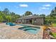 Wide shot of the stunning backyard with pool, spa, outdoor kitchen, and elegant patio area at 26221 Pheasant Run, Wesley Chapel, FL 33544