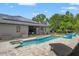 Covered outdoor dining area overlooking stunning pool and lush backyard landscaping and boat at 26221 Pheasant Run, Wesley Chapel, FL 33544