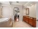 Lovely bathroom with granite countertops, soaking tub, wood cabinets, and neutral tile flooring at 26221 Pheasant Run, Wesley Chapel, FL 33544