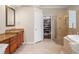 Elegant bathroom with double vanity, walk-in shower, a soaking tub, and a large walk-in closet at 26221 Pheasant Run, Wesley Chapel, FL 33544