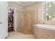 Luxurious bathroom featuring a glass-enclosed shower with dual showerheads and a separate soaking tub at 26221 Pheasant Run, Wesley Chapel, FL 33544