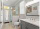 A bathroom with a single sink vanity and stand up shower and decorative mirror at 26221 Pheasant Run, Wesley Chapel, FL 33544