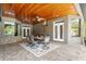 Lovely covered patio featuring a dining area, stone wall accents and gorgeous wood ceilings at 26221 Pheasant Run, Wesley Chapel, FL 33544