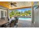 Covered outdoor dining area overlooking stunning pool and lush backyard landscaping and boat at 26221 Pheasant Run, Wesley Chapel, FL 33544