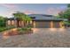 Stunning home featuring a three-car garage, stone accents, and lush landscaping at 26221 Pheasant Run, Wesley Chapel, FL 33544