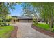 Beautiful exterior featuring a circular brick driveway, stone accents, and lush landscaping at 26221 Pheasant Run, Wesley Chapel, FL 33544