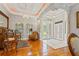 Inviting foyer with tile and wood flooring, elegant chandeliers, and decorative columns at 26221 Pheasant Run, Wesley Chapel, FL 33544