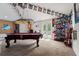 Spacious game room featuring a pool table, sports decorations, and an exit to the backyard at 26221 Pheasant Run, Wesley Chapel, FL 33544