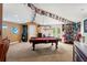 Spacious game room featuring a pool table, dart machine, sports decorations, and an exit to the backyard at 26221 Pheasant Run, Wesley Chapel, FL 33544