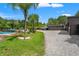 Large garage and parking area, alongside a pool and backyard with greenery at 26221 Pheasant Run, Wesley Chapel, FL 33544