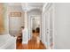 Bright hallway with hardwood floors, decorative columns, and a view into the main bedroom at 26221 Pheasant Run, Wesley Chapel, FL 33544