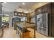 Open kitchen with island, granite countertops, stainless appliances, and seamless living area at 26221 Pheasant Run, Wesley Chapel, FL 33544