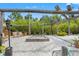 Serene outdoor space with gravel, wooden pergola, and multiple seating areas at 26221 Pheasant Run, Wesley Chapel, FL 33544