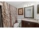 Nicely decorated bathroom with framed mirror, decorative shower curtain, and a coordinated vanity and commode at 3204 Payne St, New Port Richey, FL 34655
