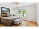 Inviting bedroom with a ceiling fan, neutral decor, and a window view of the lush, tropical landscaping at 3204 Payne St, New Port Richey, FL 34655