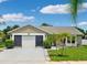 Charming single-story home featuring a two-car garage and a beautifully landscaped front yard with palm trees at 3204 Payne St, New Port Richey, FL 34655