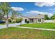 Charming home featuring a manicured lawn, mature landscaping, and a welcoming exterior at 3204 Payne St, New Port Richey, FL 34655