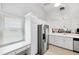 Bright kitchen featuring white cabinets, stainless steel appliances, and a built-in desk area at 3204 Payne St, New Port Richey, FL 34655