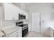 Functional kitchen featuring stainless steel appliances, white cabinets, solid surface counters, and a convenient layout at 3204 Payne St, New Port Richey, FL 34655