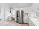 Well-lit kitchen features white cabinets, sleek stainless steel appliances, a built-in desk, and light tile flooring at 3204 Payne St, New Port Richey, FL 34655