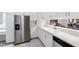 Bright kitchen featuring white cabinetry, stainless steel appliances, and a stylish breakfast bar looking into the dining room at 3204 Payne St, New Port Richey, FL 34655
