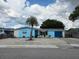 Charming blue single-story home with a gravel yard and palm tree at 3252 Columbus Dr, Holiday, FL 34691