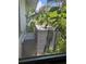 Air conditioning unit surrounded by lush greenery, seen from an indoor window at 34767 Evergreen Way, Ridge Manor, FL 33523