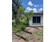 Exterior view of house showing overgrown grass and plants near a window at 34767 Evergreen Way, Ridge Manor, FL 33523