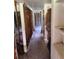 A hallway showing exposed walls, flooring, and ceiling; the space is in need of renovations to be habitable at 34767 Evergreen Way, Ridge Manor, FL 33523