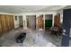 Demolished living room with exposed studs and significant debris on the floor at 34767 Evergreen Way, Ridge Manor, FL 33523