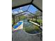 View of the screened-in pool with murky water, showing the pool and surrounding patio in need of cleaning and maintenance at 34767 Evergreen Way, Ridge Manor, FL 33523