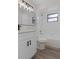 Modern bathroom featuring white vanity, black hardware, wood-look floors, and shower over tub at 3498 Plaza Ave, Spring Hill, FL 34608