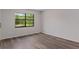Bright bedroom features wood-look flooring and a window providing plenty of natural light at 3498 Plaza Ave, Spring Hill, FL 34608