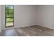 Bedroom with a bright window view and wood-look floors at 3498 Plaza Ave, Spring Hill, FL 34608
