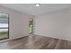 Bright bedroom with modern wood-look floors and two large windows at 3498 Plaza Ave, Spring Hill, FL 34608