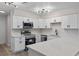 Bright kitchen features white cabinets, quartz counters, stainless appliances, and updated lighting at 3498 Plaza Ave, Spring Hill, FL 34608