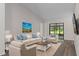 Staged living room featuring vinyl floors, a cozy seating arrangement, and plenty of natural light at 3498 Plaza Ave, Spring Hill, FL 34608